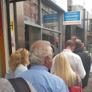 People waiting in line in front of a foreign exchange office